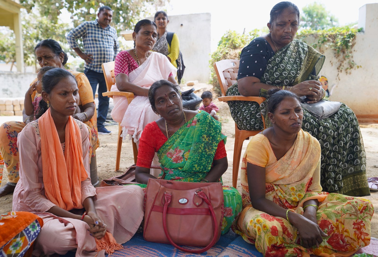 Village community members gathered for an outdoor grassroots meeting